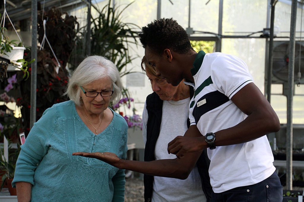 Jason Ligon explaining orchid care to visitors.