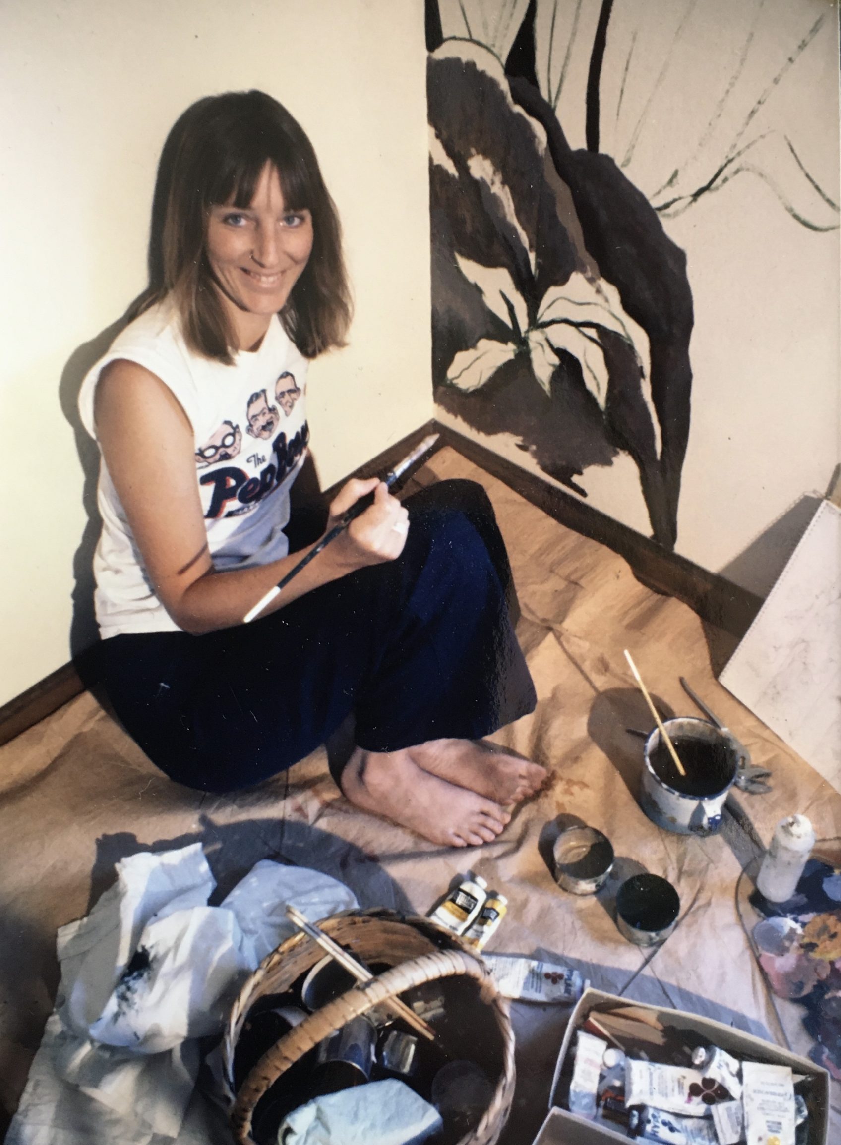 Image of artist Carolyn Schmitz working on her first jungle mural in a private home in Phoenix, Arizona in 1974.