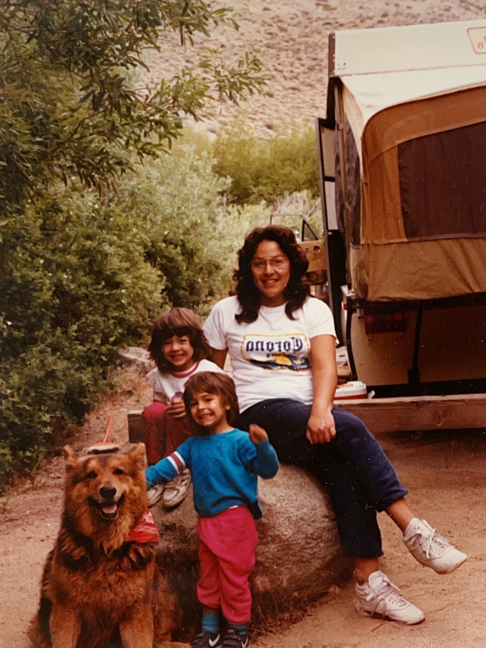 Family with large German shepherd in a campground