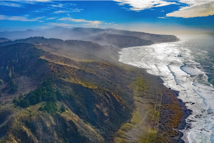 An aerial view of mountains and the Pacific Ocean